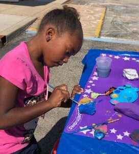 Young girl pianting rocks