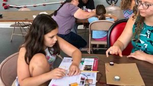A young girl working on electronics at our play museum