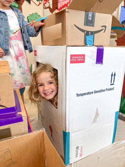 Girl playing in cardboard box