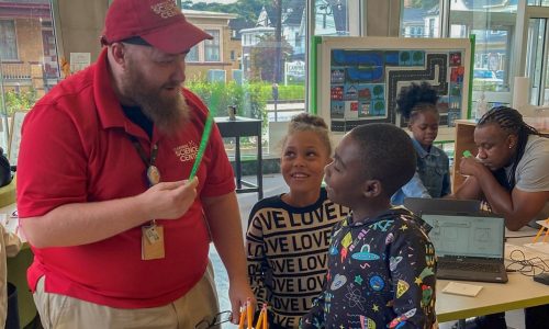 Man showing kids pencil